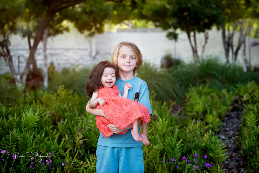 big brother holding special needs sister in a portrait